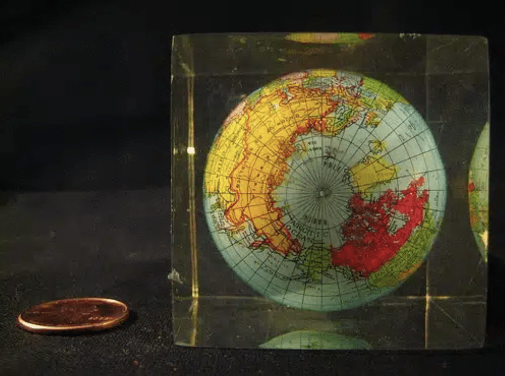 image shows globe paperweight next to a penny that was sold on eBay as a significant object due to the value of storytelling